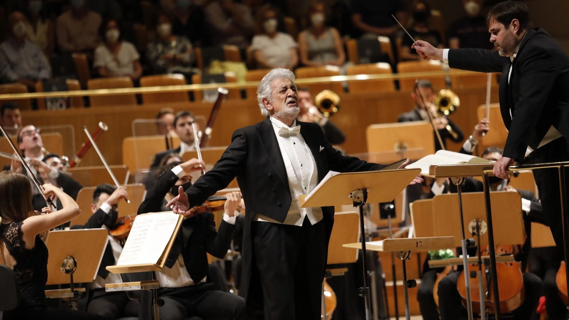 Con aplausos, vítores y parte de los asistentes en pie ha recibido el público de Madrid al tenor Plácido Domingo (c), visiblemente emocionado, en el concierto ofrecido este miércoles en el Auditorio Nacional, que ha supuesto su reaparición tras dos años alejado de los escenarios españoles.