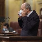 El ministro de Justicia, Juan Carlos Campo, se coloca la mascarilla en una sesión de control al Gobierno, a 16 de junio de 2021.