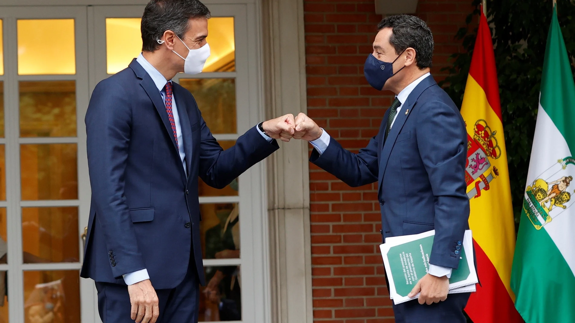 El presidente del Gobierno, Pedro Sánchez (i), saluda al presidente de la Junta de Andalucía, Juanma Moreno, a las puertas del Palacio de la Moncloa, durante su primer encuentro oficial. EFE/ J.J. Guillén