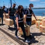 Agentes de la Guardia Civil de Huelva, junto al Servicio de Aduanas y la Policía Judiciaria de Portugal, transportan en el Muelle de Levante del Puerto de Huelva los fardos incautados. EFE/Julián Pérez