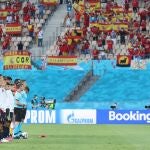 Jugadores de España escuchan los himnos nacionales antes de su encuentro.