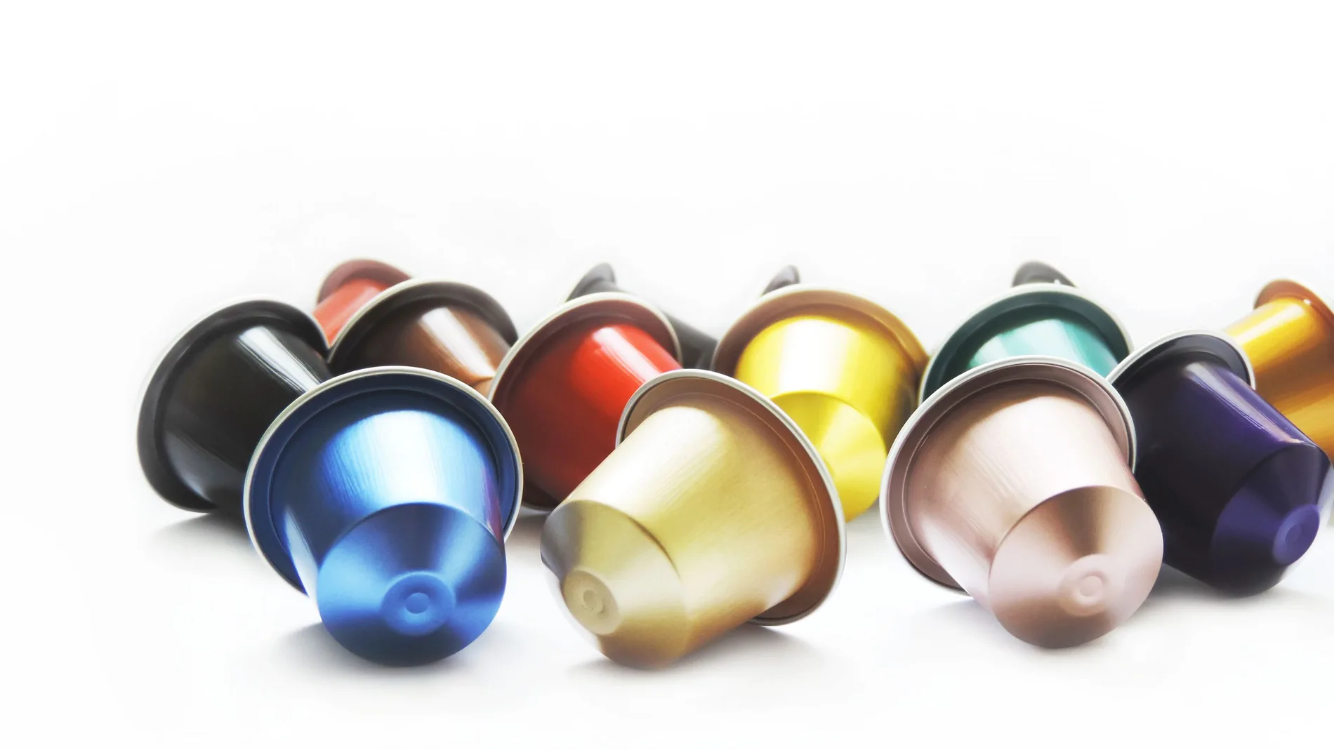 Cápsulas multicolores de café, aisladas en el fondo blanco