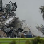 Firefighters use a ladder hose as smoke comes out of the rubble of a partially collapsed building, Thursday, June 24, 2021, in Surfside, Fla. (AP Photo/Wilfredo Lee)
