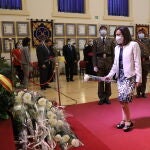 La ministra de Defensa, Margarita Robles, deja una flor en el altar durante un acto de homenaje