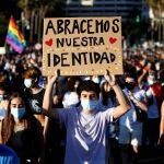Un joven lleva una pancarta con el lema "Abracemos nuestra identidad" durante la manifestación del Orgullo LGTBIQ+