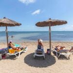 Varias personas toman el sol este jueves en la playa del Mar Menor en Los Alcázares, (Murcia).