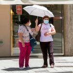 Dos mujeres se protegen del sol con una sombrila