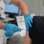 Un joven recibe la primera dosis de la vacuna en el Hospital Zendal