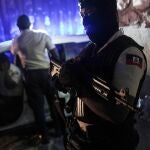 A police officer stands at an intersection in Port-au-Prince, Haiti, late Wednesday, July 14, 2021. Haiti is in the midst of a heightened security situation after the July 7 assassination of President Jovenel Moise. (AP Photo/Matias Delacroix)