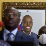 A picture of late Haitian President Jovenel Moise hangs on the wall of his former residence, behind interim Prime Minister Claude Joseph giving a press conference in Port-au-Prince, Tuesday, July 13, 2021. Authorities in Haiti on Thursday forcefully pushed back against reports that current government officials were involved in the July 7 killing of Haitian President Jovenel MoÃ¯se, calling them â€œa lie.â€ (AP Photo/Joseph Odelyn)