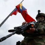 Un soldado presta guardia bajo una bandera colombiana