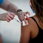 Una trabajadora sanitaria administra la vacuna contra la covid-19 a una joven