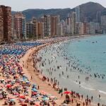 Cientos de turistas disfrutan de la playa de Levante de Benidorm, en Alicante