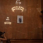 Una mujer fotografía la imagen del Rey colocada en la sala de plenos del Ayuntamiento de Barcelona