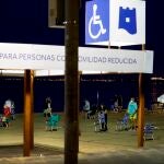 Varias personas colocan sus sillas de playa para coger sitio en alguna de las parcelas, tras hacer cola de madrugada en una playa de Torrevieja este sábado