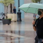 Una persona sostiene un paraguas mientras llueve, a 26 de julio de 2021, en Valencia