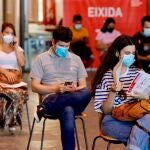Varios jóvenes esperan, este martes en el Auditori de Castelló, su turno para recibir la primera dosis de la vacuna.