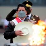 El nuevo presidente de Perú, Pedro Castillo, saluda después de encender un cáliz en honor a las víctimas del coronavirus en una base militar en Lima, Perú
