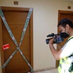 Un cámara toma imágenes de la puerta del domicilio donde presuntamente ocurrió el crimen, en Rincón de la Victoria. Álex Zea / Europa Press