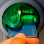Una persona saca dinero de un cajero de una entidad bancaria