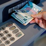 Una persona saca dinero de un cajero de una entidad bancaria