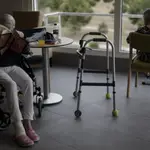 Dos residentes del Centro de Mayores Casablanca Villaverde (Av. de Rafaela Ybarra, 135) leen y descansan en un salón del centro cuatro días después de que se decretase el fin del estado de alarma por el COVID-19.