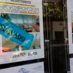 Anuncios de pisos y casas en venta y alquiler en el escaparate de una inmobiliaria, en Madrid