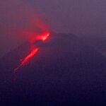 In this photo taken using slow camera shutter speed, hot lava runs down from the crater of Mount Merapi, in Sleman, Yogyakarta, Indonesia, early Monday, Aug. 9, 2021. Indonesia's most volatile volcano on the densely populated island of Java was erupting again Monday with searing gas clouds and lava flowing fast down its slopes. (AP Photo/Slamet Riyadi)