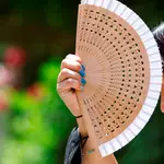 Una mujer intenta refrescarse con un abanico en el centro de Córdoba