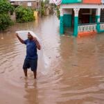 -FOTODELDIA- AME8333. SAN CRISTÓBAL (REPÚBLICA DOMINICANA), 12/08/2021.- Un hombre camina por una de las calles inundadas en el barrio Moscú tras el paso de la tormenta Fred, hoy, en San Cristóbal (República Dominicana). Un total de 580.186 usuarios quedaron sin agua y 439.263 sin electricidad por los efectos de Fred sobre la República Dominicana, donde ayer como tormenta tropical arrojó fuertes lluvias, según el reporte ofrecido este jueves por el Centro de Operaciones de Emergencias (COE). EFE/ Orlando Barría