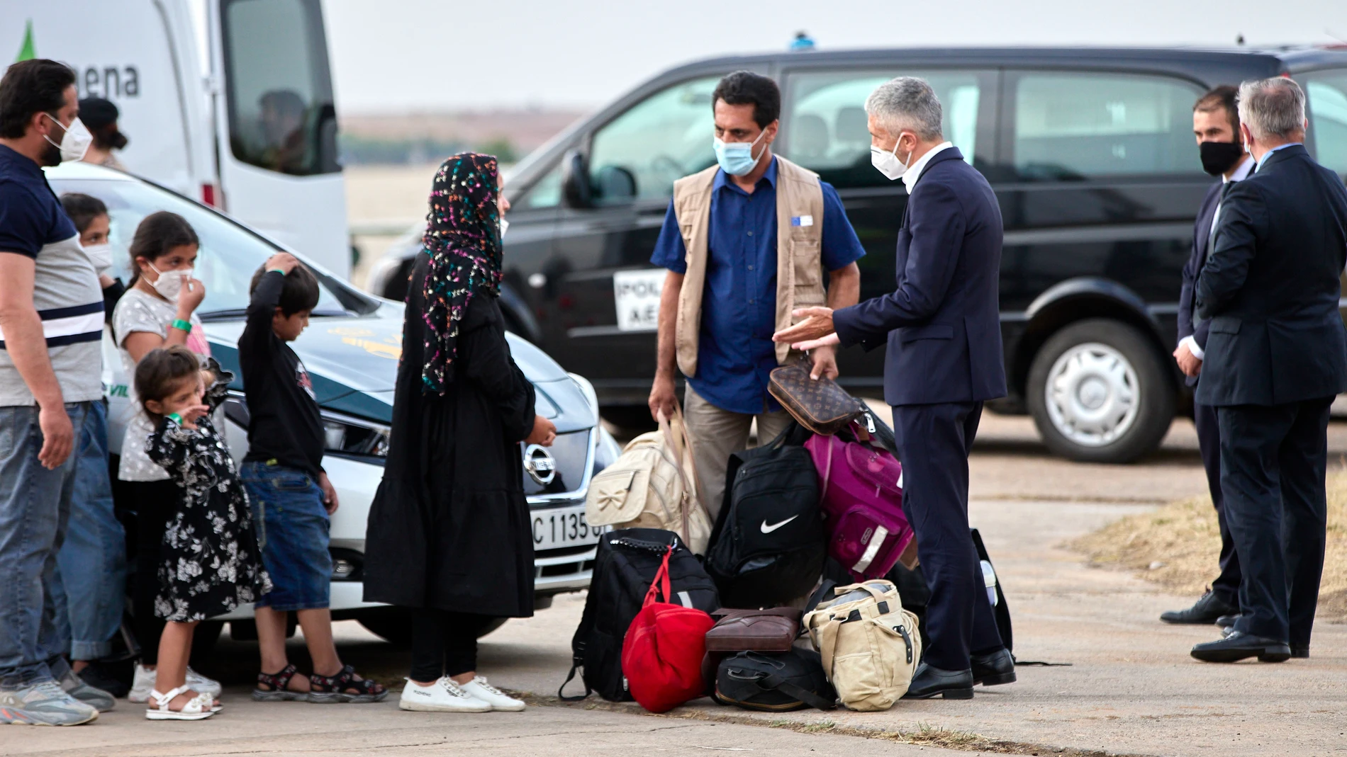 El ministro de Interior, Fernando Grande-Marlaska (3d) saluda a varios refugiados en la base aérea de Torrejón de Ardoz (Madrid)