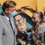 El presidente de la Generalitat, Ximo Puig, conversa esta mañana con una fallera al lado de las fallas afectadas por las fuertes lluvias caídas en Valencia por el temporal DANA