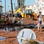Una vecina participa en los trabajos de limpieza por los daños causados en les Cases d'Alcanar (Tarragona) por la lluvia torrencial, que ayer descargó 77 litros de agua por metro cuadrado en media hora..EFE/Quique García