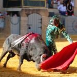 El diestro peruano Andrés Roca Rey da un pase con la muleta a uno de los de su lote, durante la corrida Goyesca celebrada este sábado en la Real Maestranza de Ronda, en Málaga.