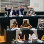 Marta Higueras; José Manuel Calvo, y Luis Cueto, levantan la mano acompañados de concejales de Más Madrid durante la sesión