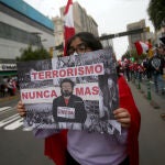 12 September 2021, Peru, Lima: A woman carries a placard describing Peruvian guerrilla leader Guzman as a mass murderer at a demonstration marking his death. Abimael Guzman, the former leader of the Peruvian guerrilla organization Shining Path (Sendero Luminoso), died at the age of 86 in a maximum-security prison, the prison administration announced on Saturday. Almost 70,000 people were killed in clashes between the Sendero Luminoso and state security forces between 1980 and 2000. Photo: Cesar Lanfranco/dpa12/09/2021 ONLY FOR USE IN SPAIN