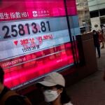 Hong Kong (China), 13/09/2021.- Pedestrians walk past an electronic billboard displaying information on the Hang Seng Index (HSI) in Hong Kong, China, 13 September 2021. The HSI fell 1.5 percent, or 392 points, to 25,813. EFE/EPA/JEROME FAVRE