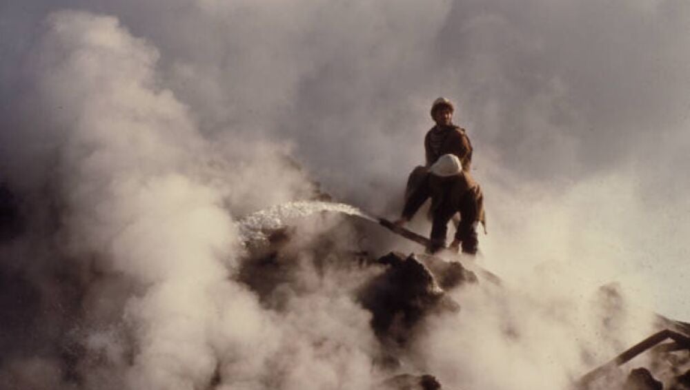 Dos operarios enfriando la lava bajo la capa solidificada