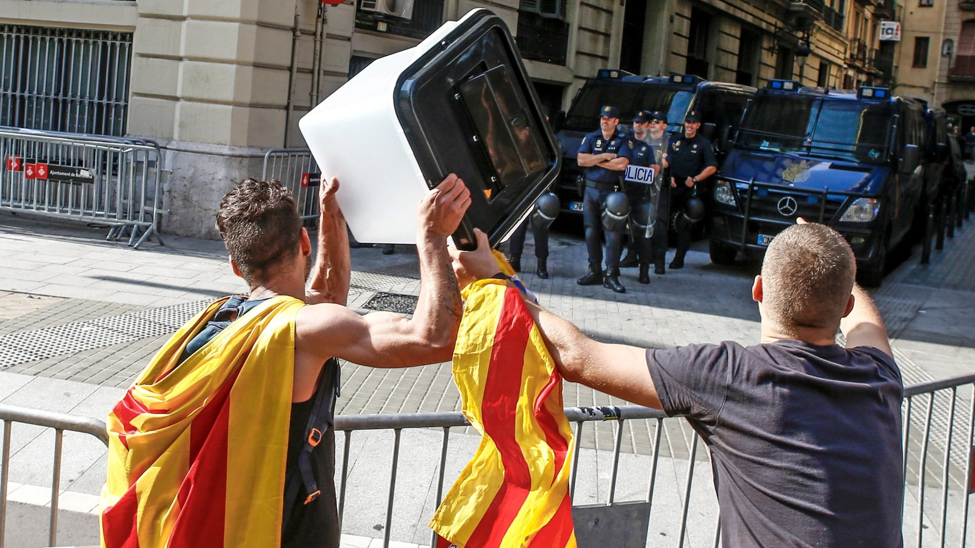 Dos jóvenes muestran una urna empleada el 1-O en una protesta