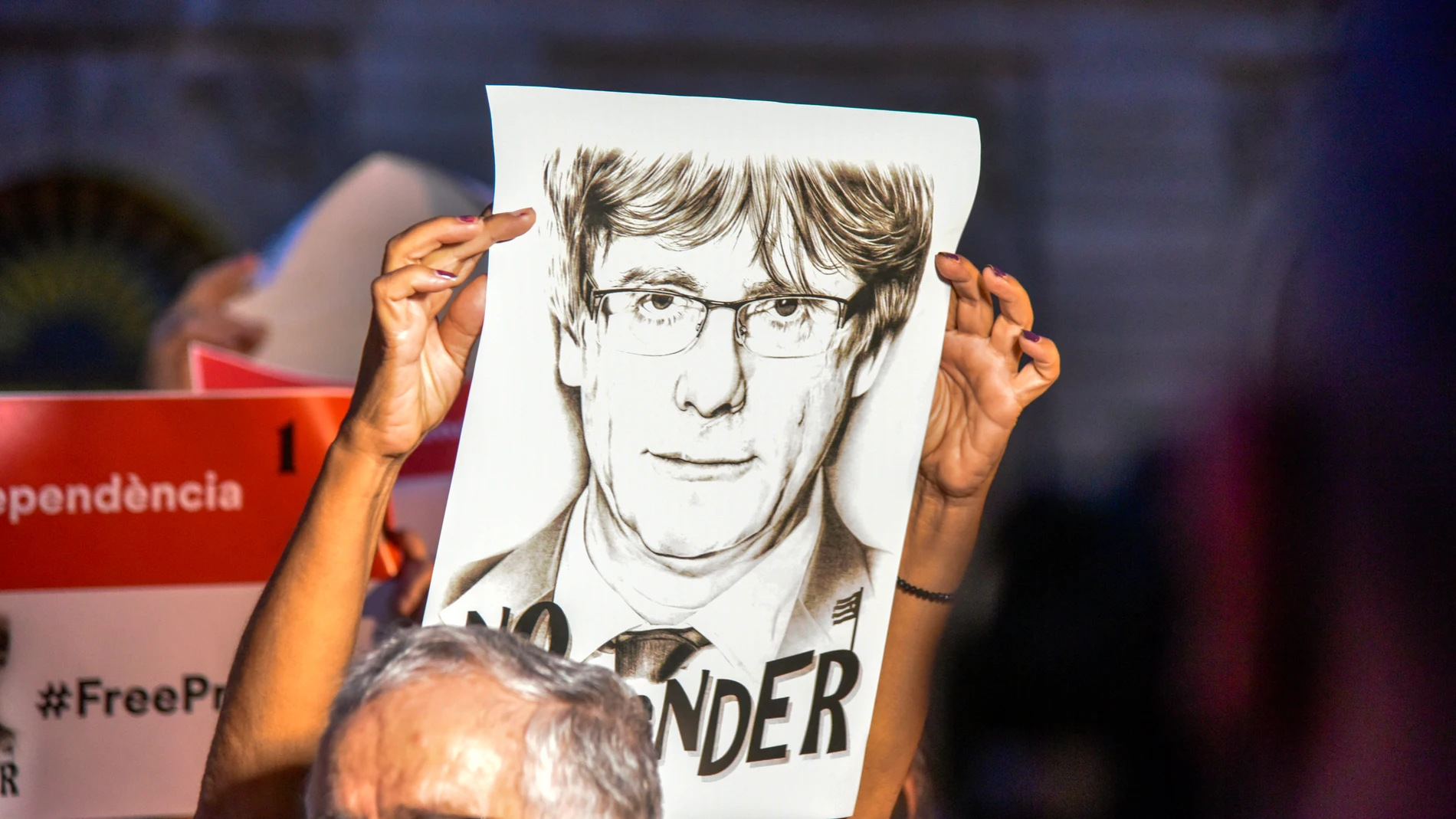 Una mujer sostiene una pancarta durante una concentración en apoyo al vicepresidente de la Generalitat, Carles Puigdemont, en la plaza de San Jaume de Barcelona