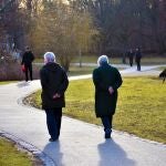Una pareja jubilada pasea por un parque