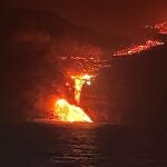 La colada de lava en el momento en que alcanza el mar en la isla de La Palma, en una imagen tomada desde el buque oceanográfico Ramón Margalef