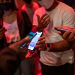 Una persona muestra un código QR para entrar a un local de ocio nocturno