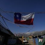 A Chilean flag hangs inside a camp where migrants from Haiti, Peru and Colombia, set up a homes and call "Dignidad," or Dignity, in Santiago, Chile, Thursday, Sept. 30, 2021. There are 180,000 Haitians in Chile, of whom â€œalmost 70,000 reside in the country permanently,â€ said deputy interior minister Juan Francisco Galli. (AP Photo/Esteban Felix)