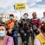 Una mujer con un cartel en el que se lee: 'Recortar es maltratar', participan en una concentración de pensionistas en la Puerta del So