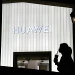 Una mujer pasa por delante de una tienda de Huawei en Pekín