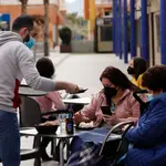 Un camarero atiende a dos clientas en la terraza de un bar, en Alcantarilla, Murcia (España)