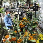 Germán Capultitla observa las tumbas recién decoradas de su tía María Guadalupe y su abuela Flora en el cementerio Xilotepec en el Xochimilco, un barrio al sur de Ciudad de México famoso por sus canales estilo veneciano.