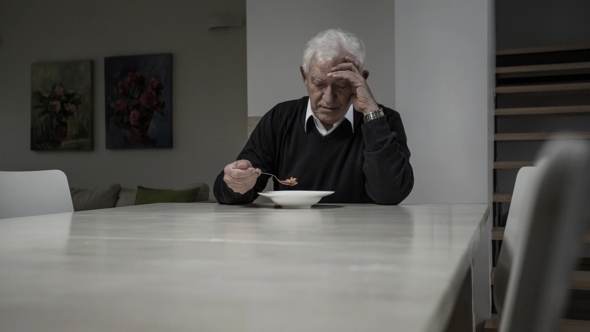 Persona mayor comiendo sola