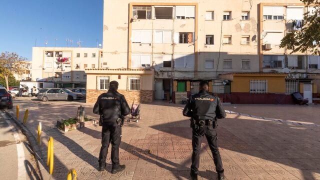 Agentes de la Policía Nacional, frente a la vivienda del número 231 de la calle Estanislao Rolandi de Cartagena, donde el sábado por la noche resultó muerto un hombre y otros dos resultaron heridos de bala, uno de ellos muy grave por un disparo en el cráneo, en un tiroteo entre traficantes de droga en la barriada Virgen de la Caridad, de Cartagena (Murcia)
